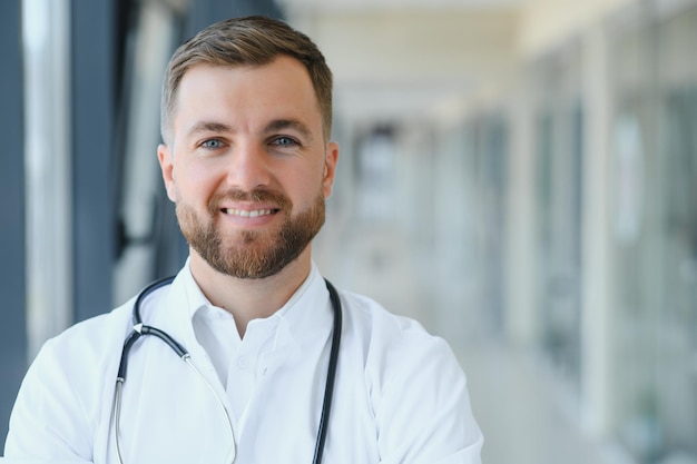 Porträt eines männlichen Arztes, der in einem Krankenhausflur steht