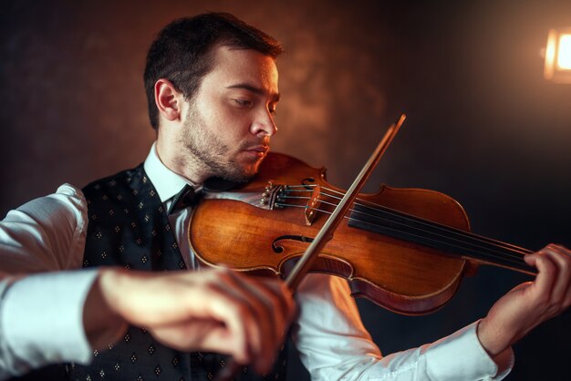 Porträt eines männlichen Geigers, der klassische Musik auf Geige spielt. Geiger mit Musikinstrument