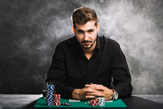 Porträt eines männlichen Spielers mit Kasinochips und Spielkarten