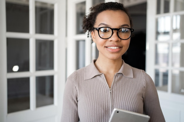 Porträt eines Managers, der eine freiberufliche Frau lächelt, die mit Brille in die Kamera schaut