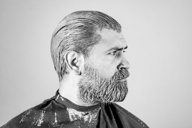 Porträt eines Mannes, der Haare färbt, bärtiger Hipster-Typ, Prozess eines Mannes, der seine Haarfarbe beim Friseur hat ...