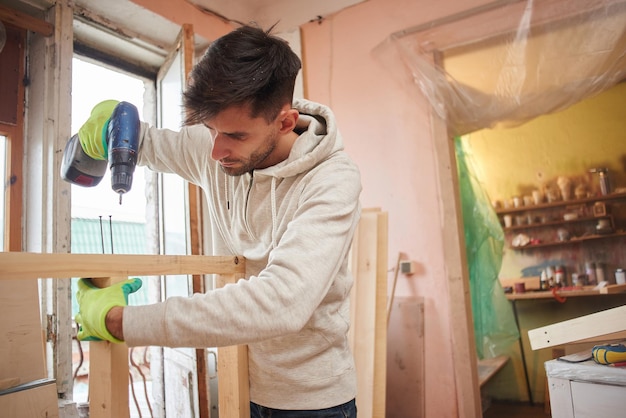 Porträt eines Mannes, der in einer Heimwerkstatt arbeitet