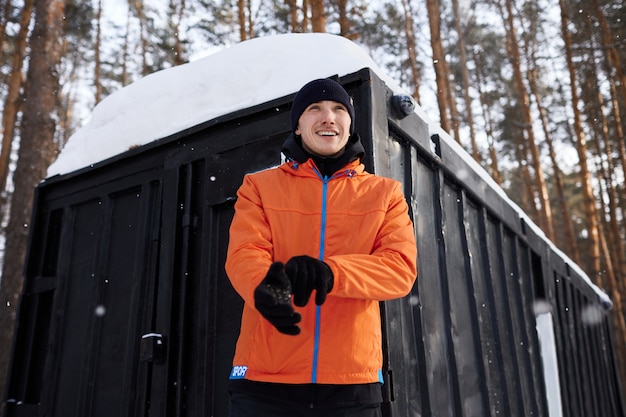 Porträt eines Mannes, der sich im Park an einem schönen verschneiten Wintertag ausdehnt und sich auf das Laufen vorbereitet