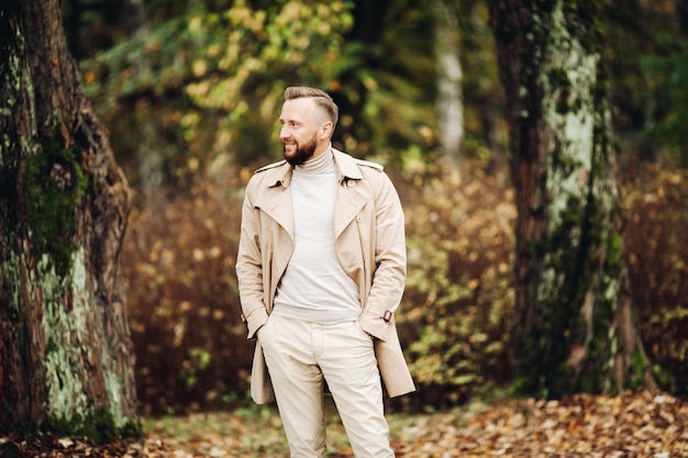 Porträt eines Mannes im Wald mit Herbstlaub hinter sich