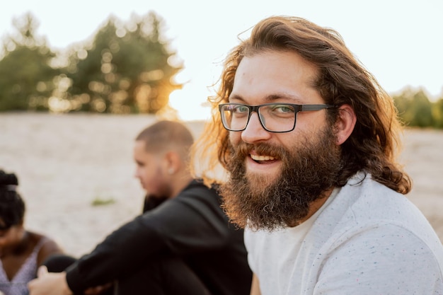 Porträt eines Mannes mit Brillenbart und langen Haaren. Der Typ trägt einen bequemen T-Shirt-Hipster