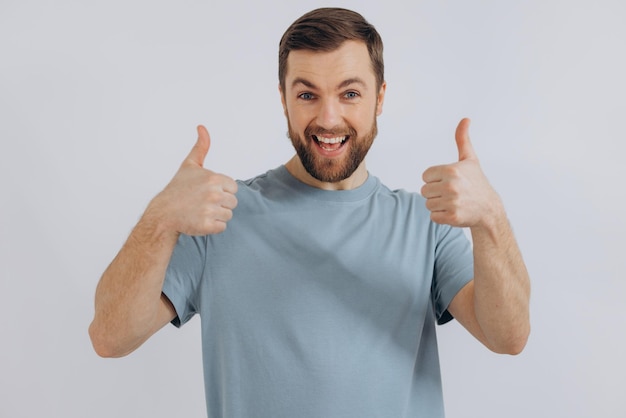 Porträt eines modernen bärtigen Mannes mittleren Alters in einem blauen T-Shirt, das gute Gefühle auf weißem Hintergrund zeigt