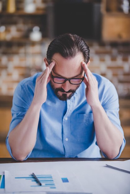 Porträt eines müden Geschäftsmannes mit Migräne nach der Arbeit im Heimbüro