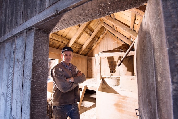 Porträt eines Müllers in Retro-Wassermühle aus Holz mit alter Ausrüstung