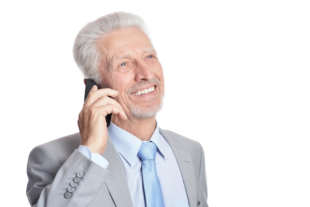 Porträt eines nachdenklichen älteren Mannes mit Smartphone isoliert auf weißem Hintergrund