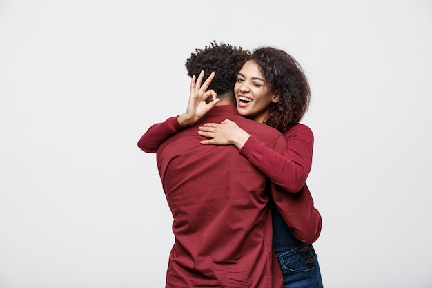 Porträt eines netten jungen afrikanischen Paares, das zusammen steht und okaygeste zeigt.