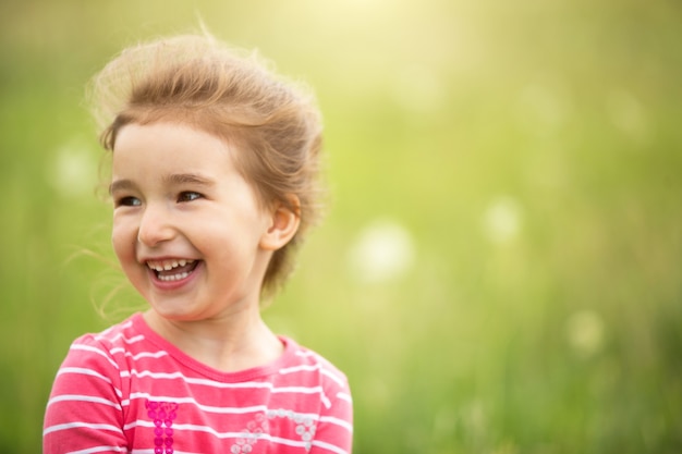 Porträt eines netten Mädchens im Feld mit einer wilden Blume. Kindheit, Urlaub auf dem Land, Freiheit und Sorglosigkeit. Sommerzeit. Internationaler Kindertag. Mückenschutz, Hüttenkern. Platz kopieren