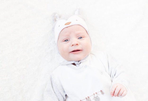 Porträt eines Neugeborenen in einem Hut mit Ohren auf einem Weiß