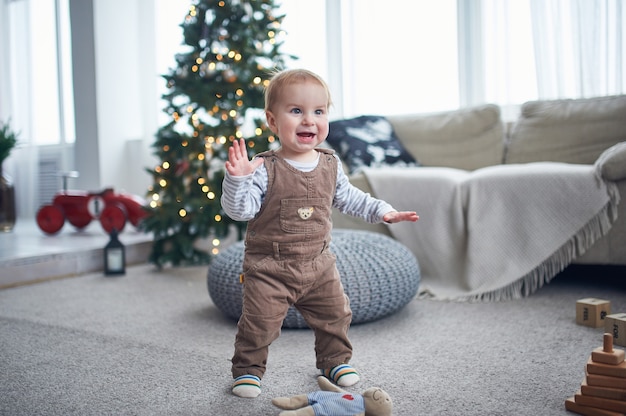 Porträt eines niedlichen 1-jährigen Jungen, der auf dem Boden steht.