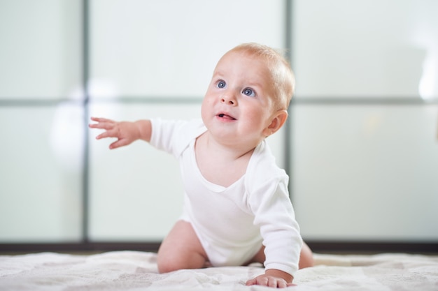 Porträt eines niedlichen 6 Monate alten Jungen, der auf dem Boden kriecht