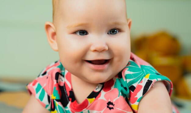 Foto porträt eines niedlichen babys mit blauen augen in farbenfrohem kleid