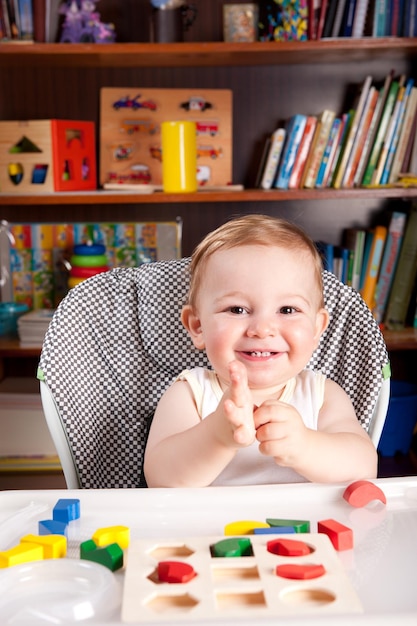 Porträt eines niedlichen Jungen, der mit Spielzeugblöcken auf dem Tisch spielt