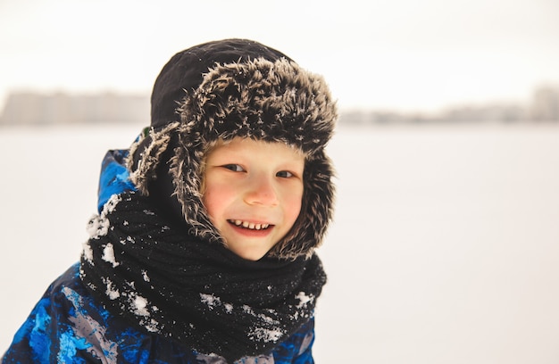 Porträt eines niedlichen Jungen in einem Hut im Winter draußen