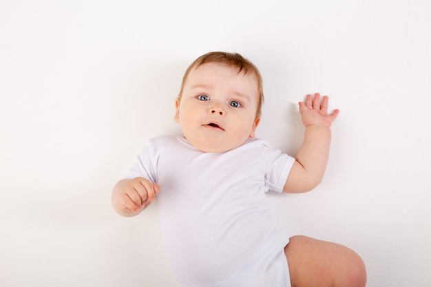 Porträt eines niedlichen Jungen mit blauen Augen in einem weißen Bodysuit