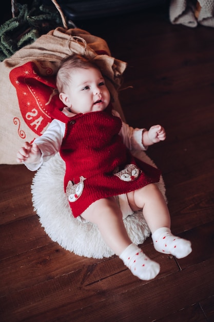 Porträt eines niedlichen kleinen Mädchens im roten Strickkleid