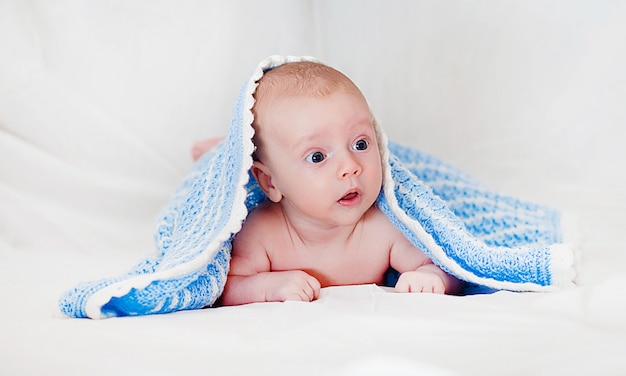Porträt eines niedlichen lächelnden Säuglingsbabys, das in einer Windel kriecht