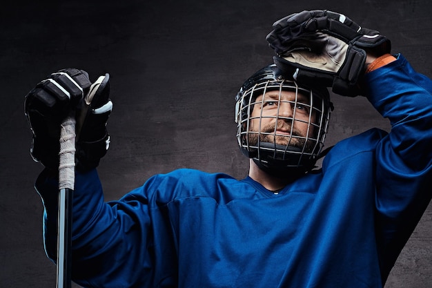 Porträt eines professionellen Eishockeyspielers in einer Hockeyuniform. Studioaufnahme.
