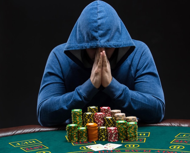 Porträt eines professionellen Pokerspielers, der am Pokertisch sitzt