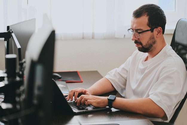 Porträt eines professionellen Programmierers, der konzentriert am Computer in verschiedenen Büros arbeitet. Moderne IT-Technologien, Entwicklung von Programmen für künstliche Intelligenz, Anwendungen und Videospielkonzept