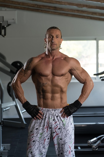 Porträt eines reifen körperlich fitten Tätowierers, der seinen gut trainierten Körper zeigt muskulöser athletischer Bodybuilder Fitness Model posiert nach Übungen