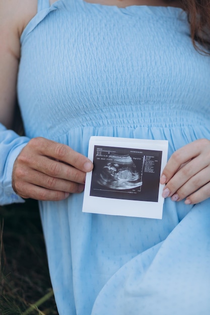 Porträt eines reizenden Paares, das zusammen auf der grünen Wiese steht Glückliches Paar, das ein junges Familienkonzept des Babys erwartet