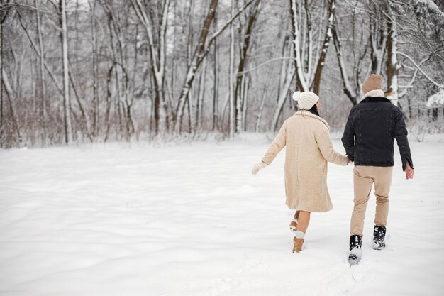 Porträt eines romantischen Paares, das am Wintertag Zeit zusammen im Wald verbringt