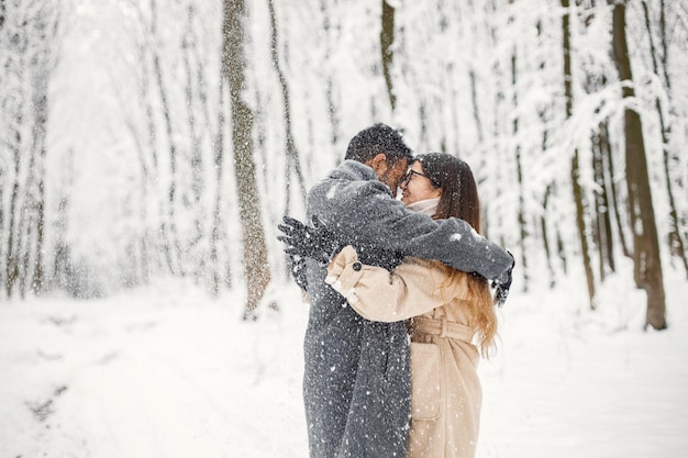 Porträt eines romantischen Paares, das Zeit zusammen im Winterwald verbringt
