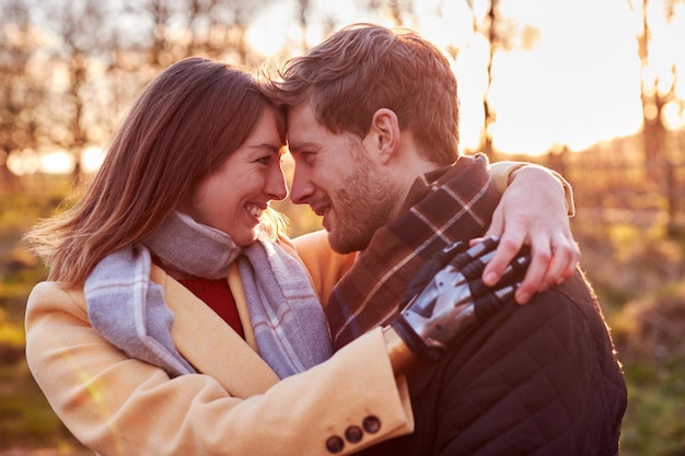 Porträt eines romantischen Paares mit einer Frau mit prothetischer Hand, die sich im Winter oder im Herbst auf dem Land umarmt