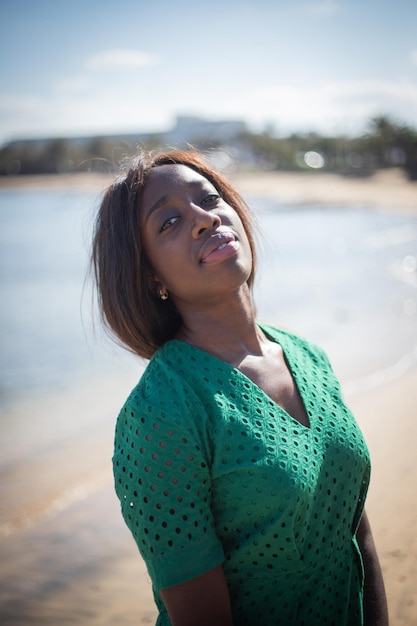 Porträt eines schönen afrikanischen tausendjährigen Mädchens, das im Sommer in die Kamera schaut, Frau am Strand an einem exotischen Ort. Afrikanische ethnische Schönheit.