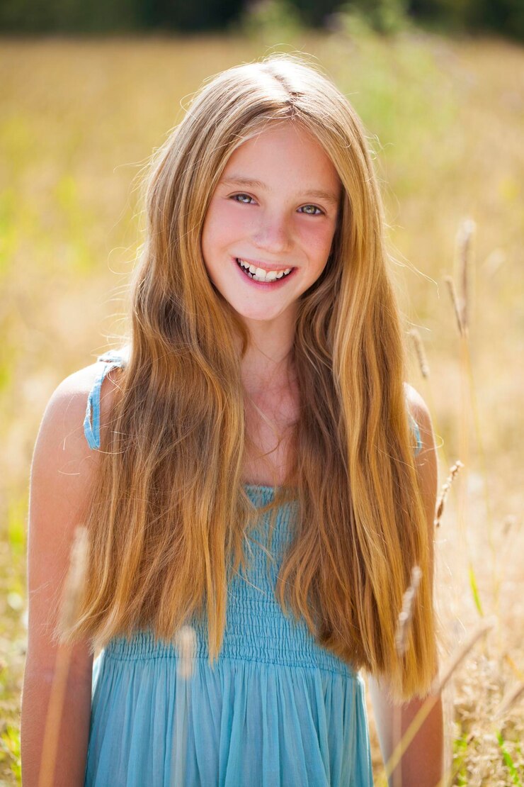 Foto porträt eines schönen jungen blonden kleinen mädchens auf dem hintergrund eines sommerparks