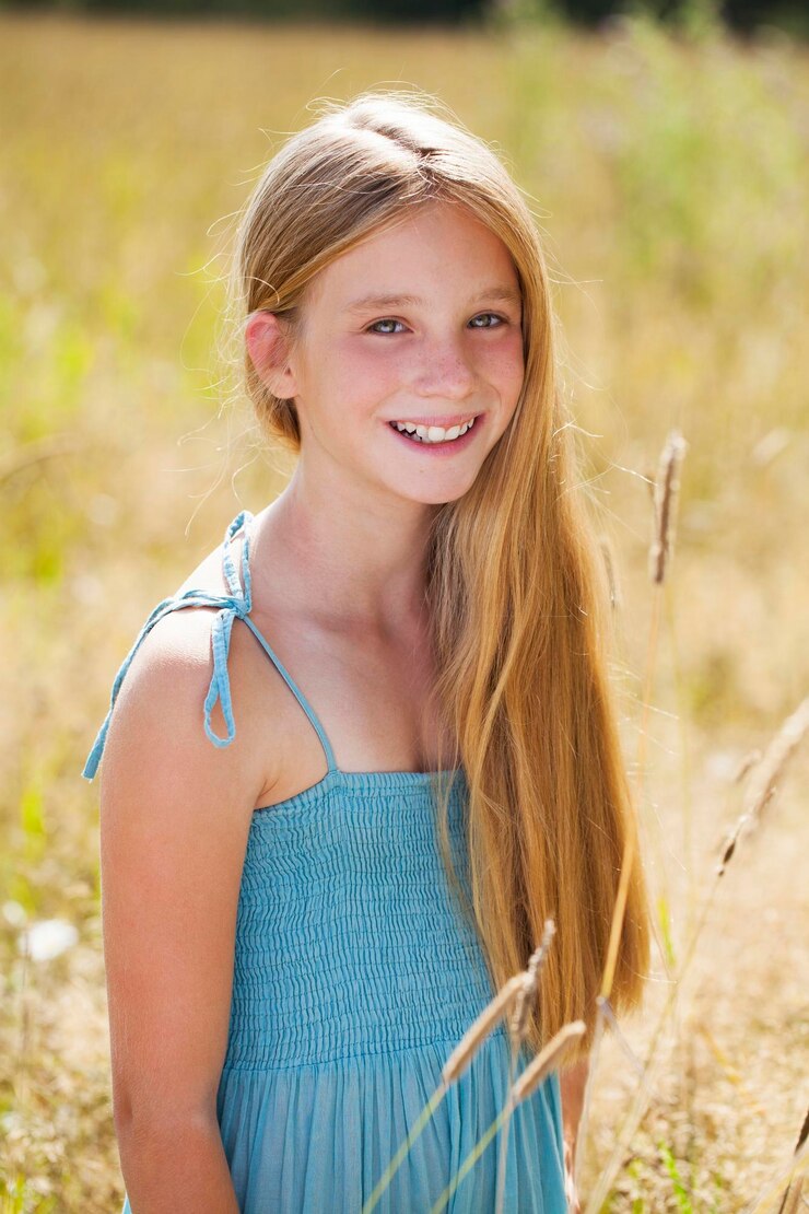 Foto porträt eines schönen jungen blonden kleinen mädchens auf dem hintergrund eines sommerparks