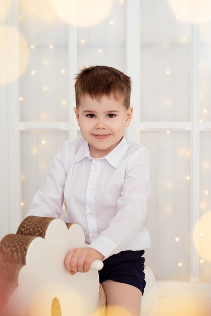 Foto porträt eines schönen jungen in den lichtern einer weihnachtsgirlande. weihnachten