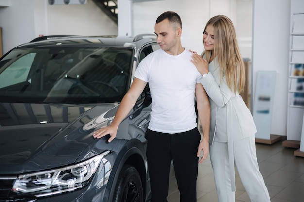 Porträt eines schönen jungen Paares glücklich nach dem Kauf eines neuen Autos von der Autohausfrau hus ihr Mann