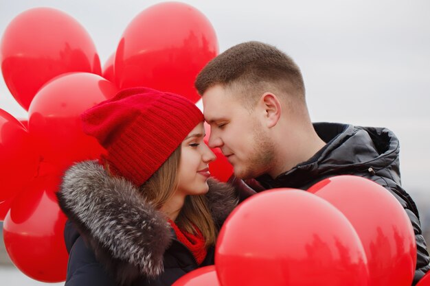 Porträt eines schönen jungen Paares mit roten Luftballons