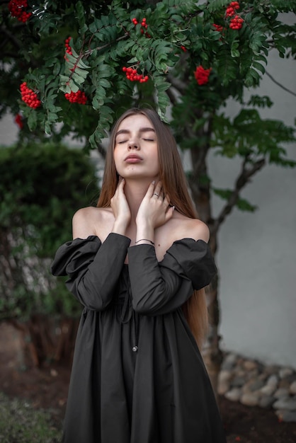 Porträt eines schönen Mädchens auf dem Hintergrund eines Baumes mit Blumen