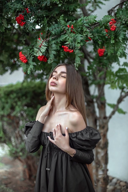 Porträt eines schönen Mädchens auf dem Hintergrund eines Baumes mit Blumen