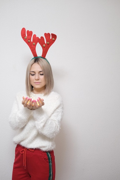 Porträt eines schönen Mädchens auf hellem Hintergrund Das Konzept von Weihnachten und Neujahr