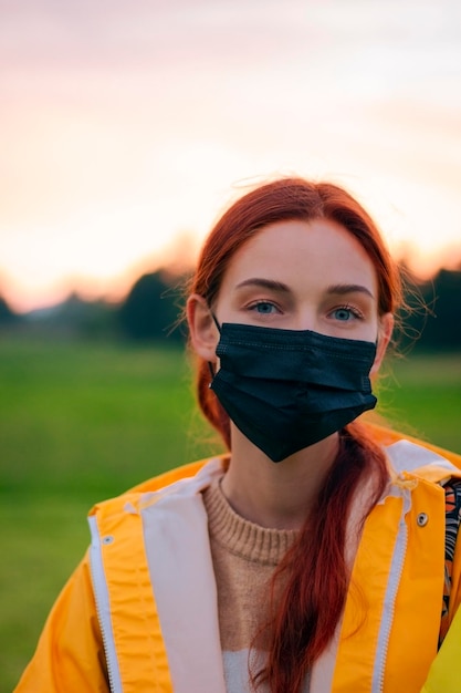 Porträt eines schönen Mädchens mit Brille und schwarzer Maske Pandemie Das Mädchen auf dem Hintergrund der Natur