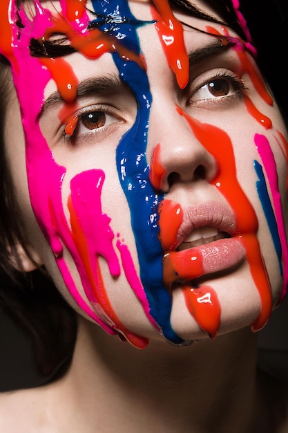 Porträt eines schönen Mädchens mit roter Farbe auf ihrem Gesicht Fotoaufnahme im Studio
