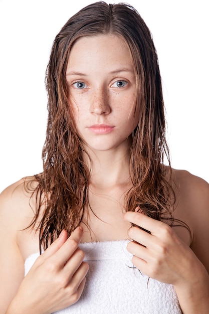 Porträt eines schönen Modells mit nassem Haar und sauberer Haut und Sommersprossen nach der Dusche auf weißem Hintergrund.
