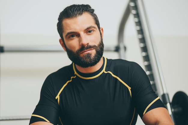 Foto porträt eines schönen, verschwitzten mannes nach einer trainingssitzung im fitnessstudio, eines sportlichen jungen am ende des trainings