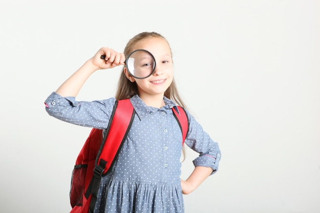 Porträt eines Schulmädchens mit Rucksack und Briefpapier