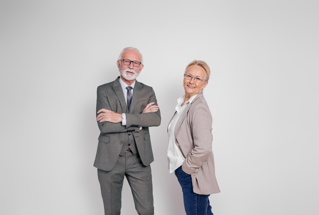 Porträt eines selbstbewussten Geschäftsmanns und einer Geschäftsfrau, die lächeln und auf weißem Hintergrund posieren