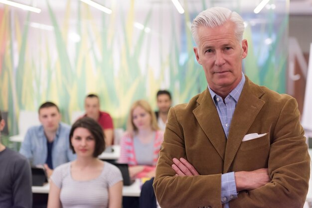 Foto porträt eines selbstbewussten lehrers, studentengruppe im hintergrund