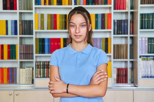 Porträt eines selbstbewussten Teenager-Schulmädchens, das die Kamera in der Bibliothek anschaut