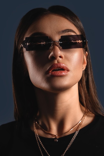 Porträt eines sexy Mädchens in außergewöhnlicher Sonnenbrille wie Rasierklingen-Umrissdesign